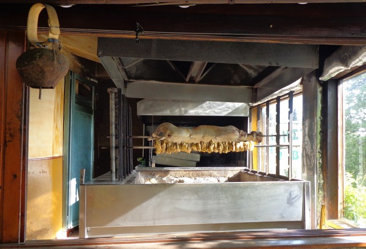 Goats roasting on charcoal fire in a tavern.