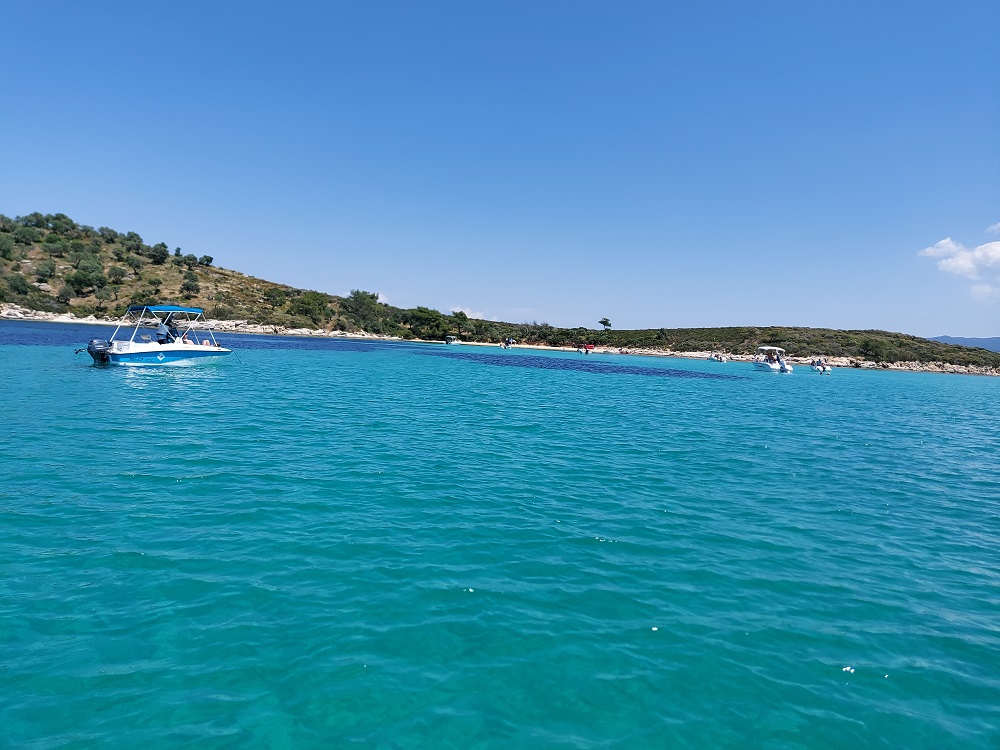 Boats in the Blue Lagoon of Diaporos Island in Greece.